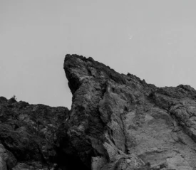 Jagged rock formation rising sharply against a clear sky in a black‑and‑white landscape