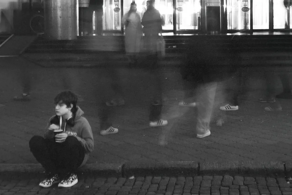 Young person sitting on the curb with blurred background
