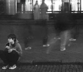Young person sitting on the curb with blurred background