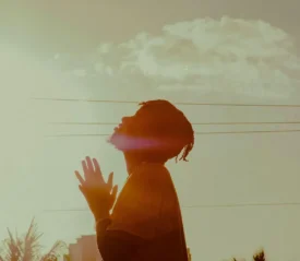 Man with folded hands and lifted head in prayer