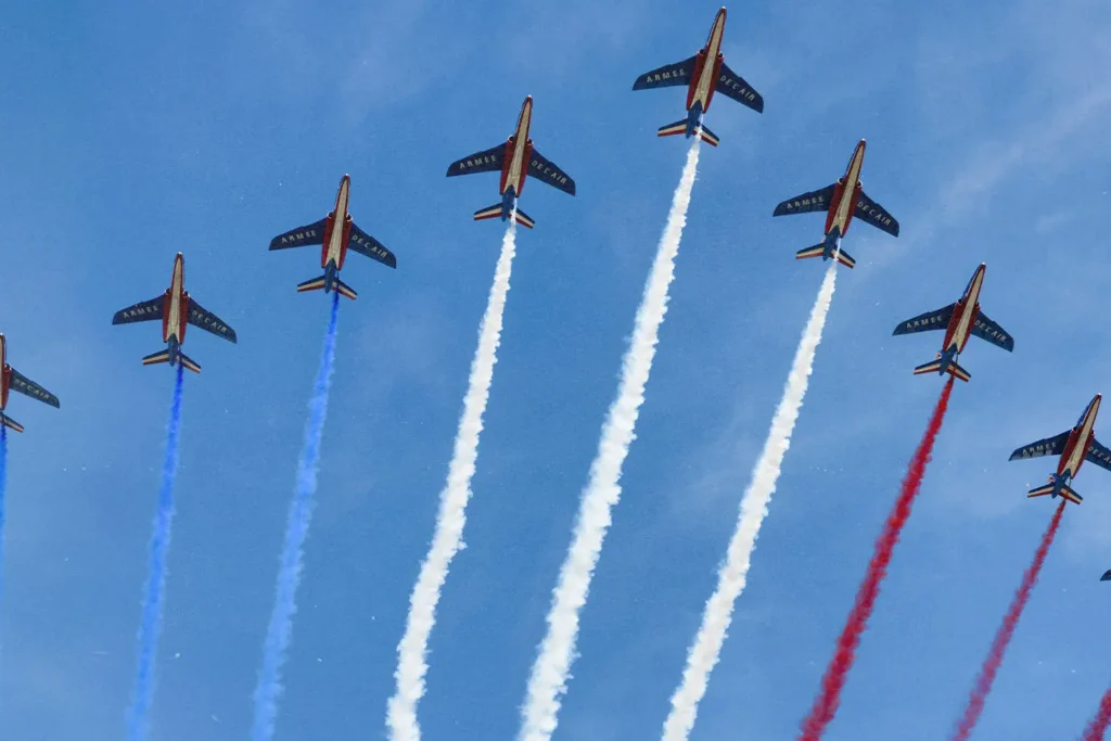 Line of fighter jets letting off red, white, and blue chemtrails