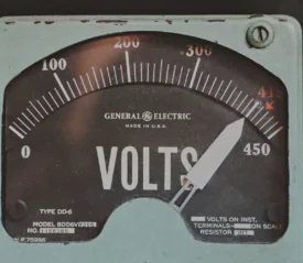 Close-up of an analog General Electric voltmeter with a needle pointing near 415 volts