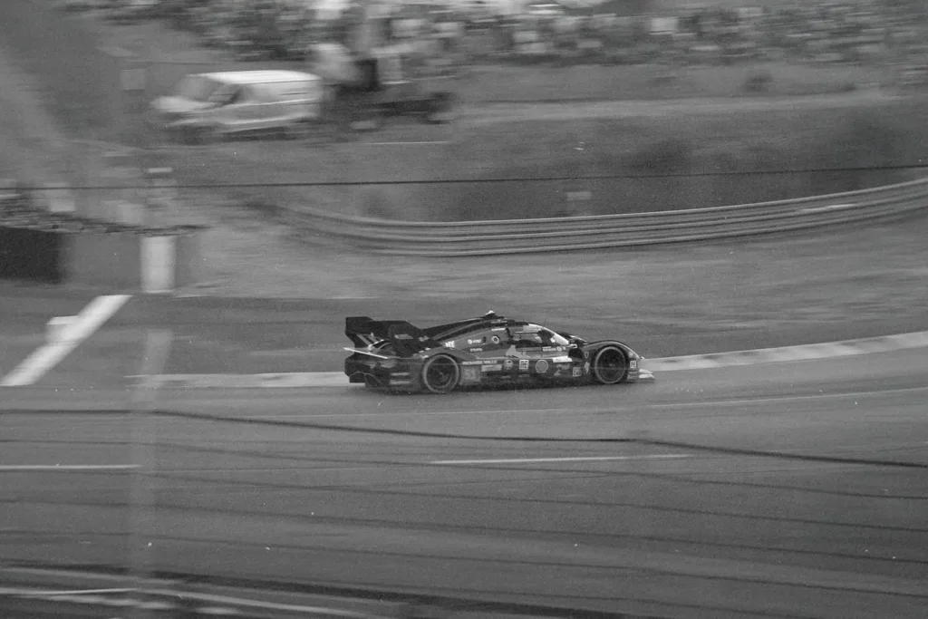 black and white photo of race car driving on track