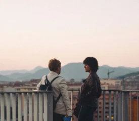 Two people talking on a balcony