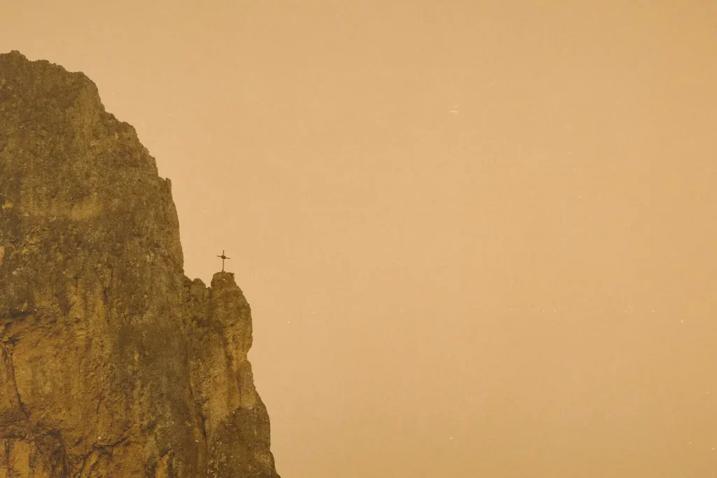 Cross on the edge of a cliff in the distance