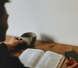 Man with coffee mug reading the Bible
