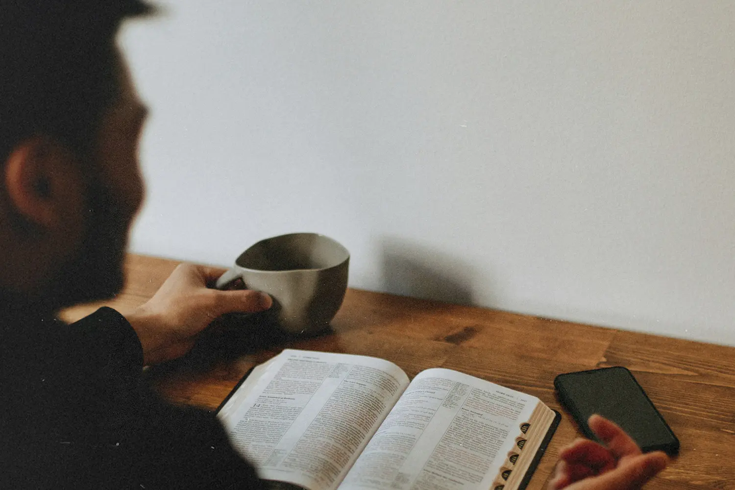 Man with coffee mug reading the Bible