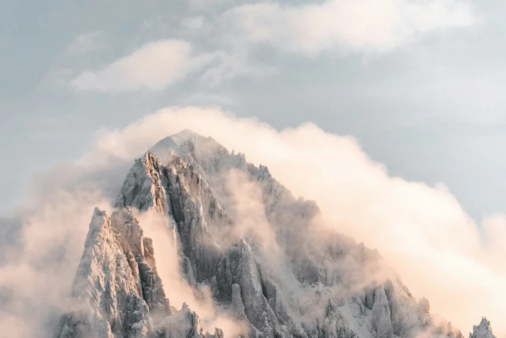 Fog settling over the peak of a snowy mountain