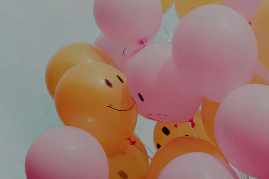 Bunch of orange and pick balloons with smiley faces