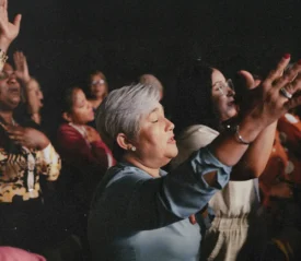 Woman with eyes closed and lifted hands in worship