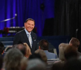 Kenneth Copeland smiling at a congregation