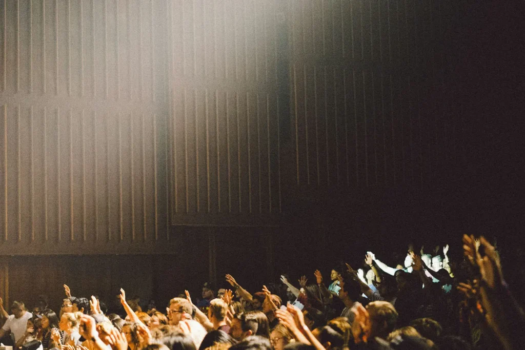 crowd of people with their hands raised in worship