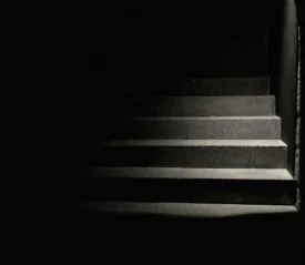 spotlight shining in a dark room on concrete stair steps