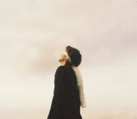 blindfolded person looking up at a white sky