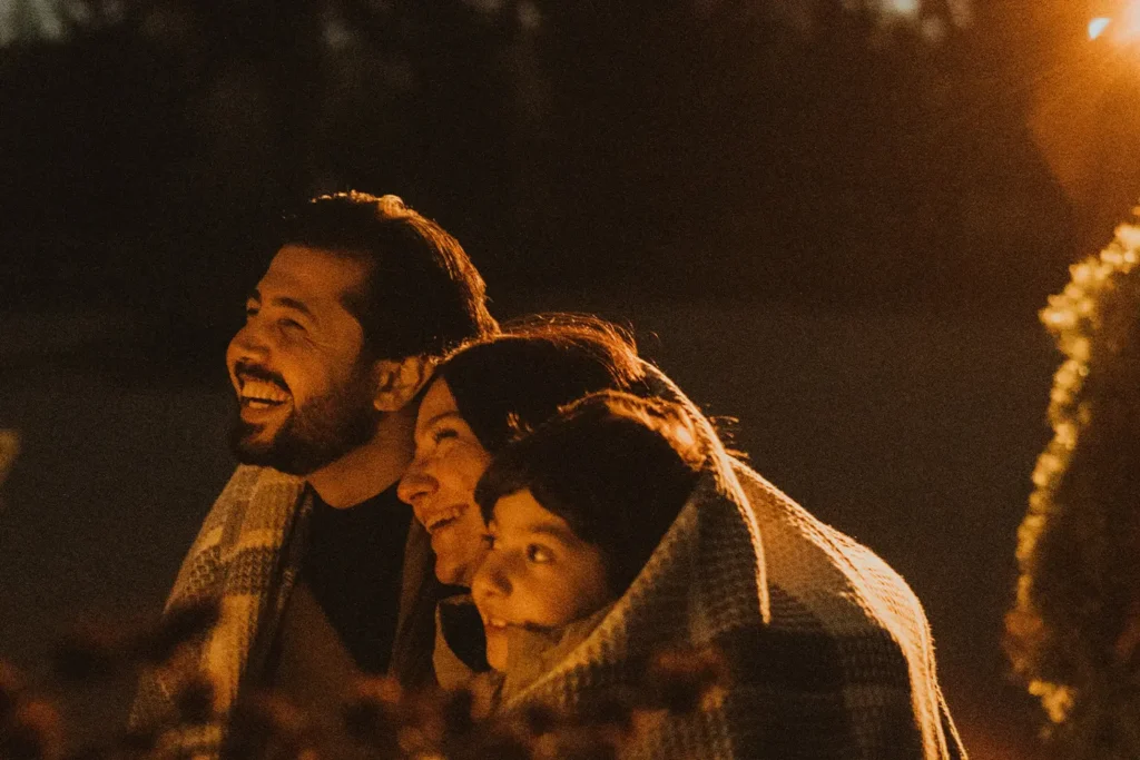 smiling family sharing a blanket