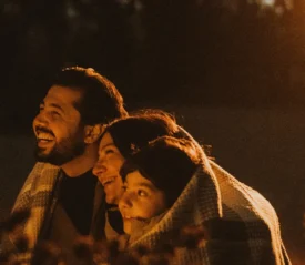 smiling family sharing a blanket