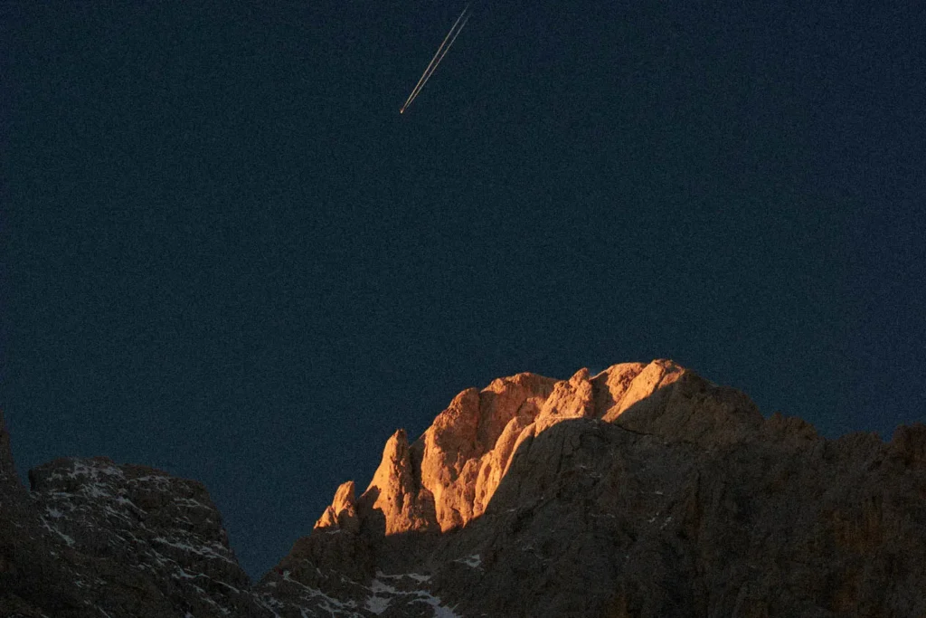 plane in the sky over a mountain