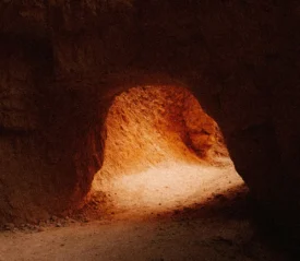 sun peeking into the opening of a cave