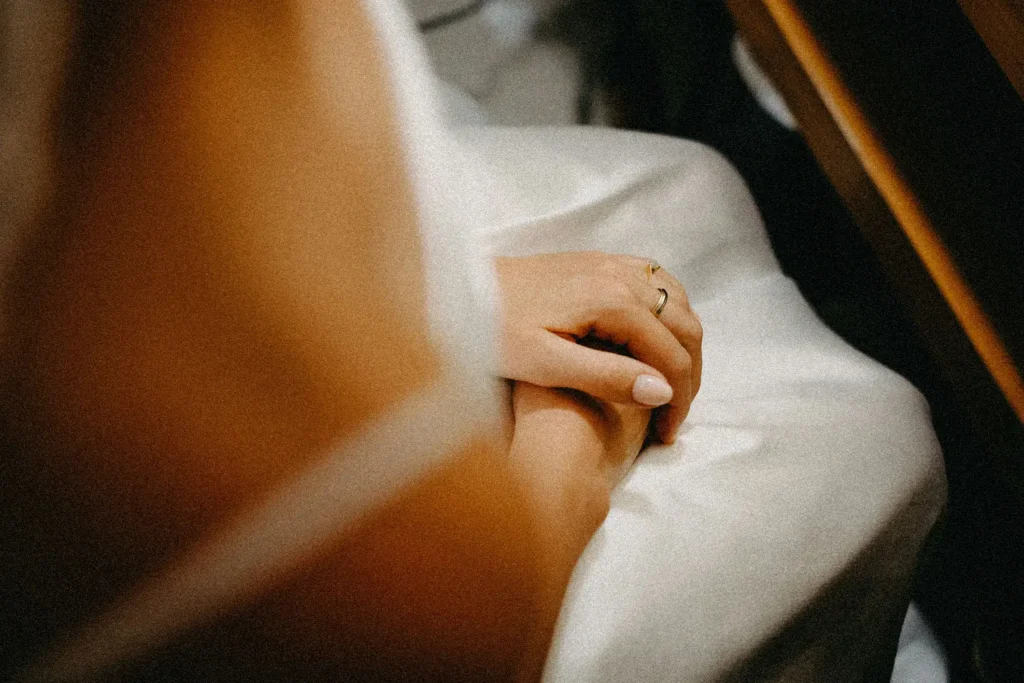 praying hands in a woman's lap