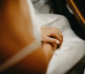 praying hands in a woman's lap