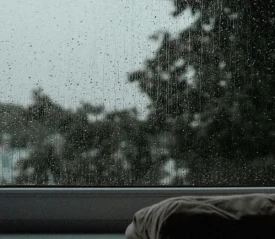 rain streaks down a closed window