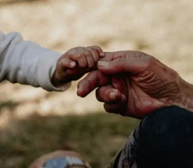 child's hand holding an elderly finger