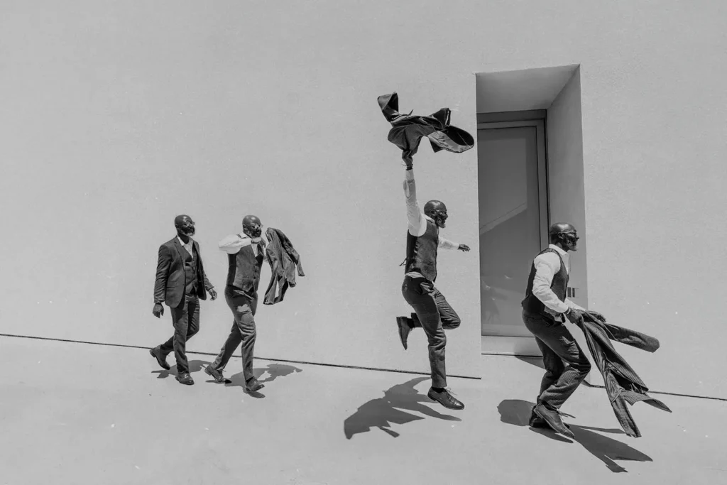 4 men in suits walking with excitement