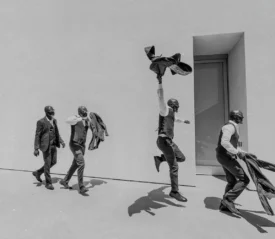 4 men in suits walking with excitement