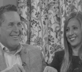 Randy Roberts and woman sitting with a smile