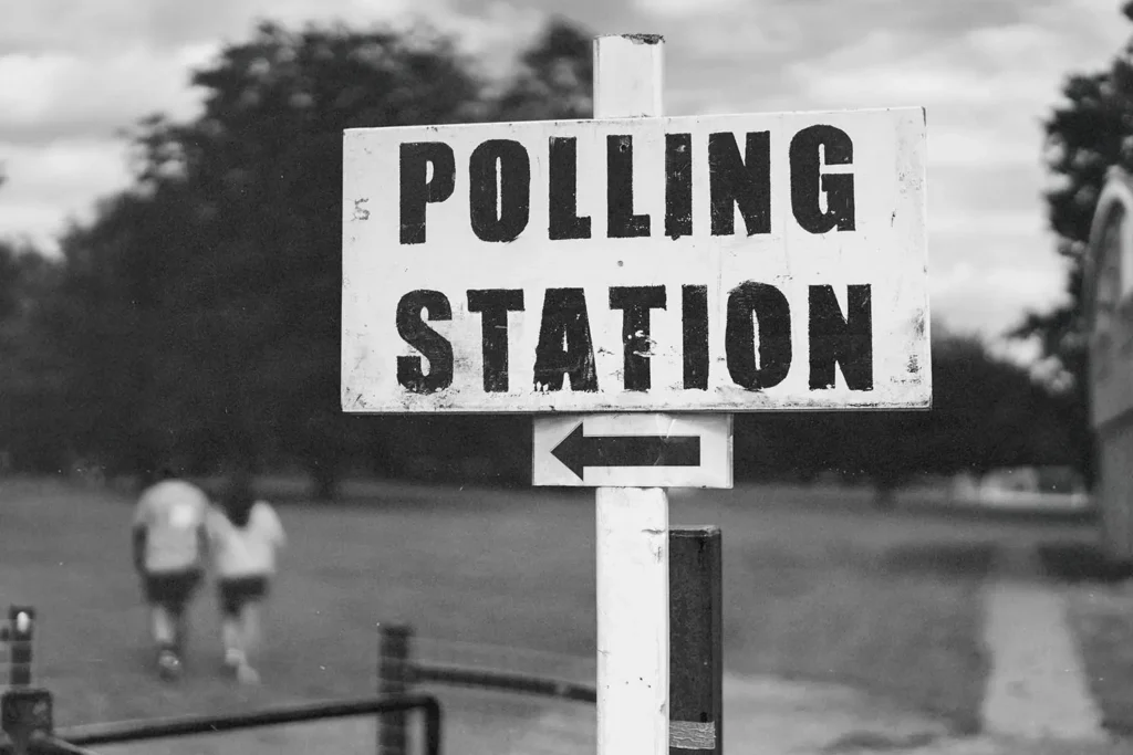 Post sign that reads "POLLING STATION" and an arrow pointing left
