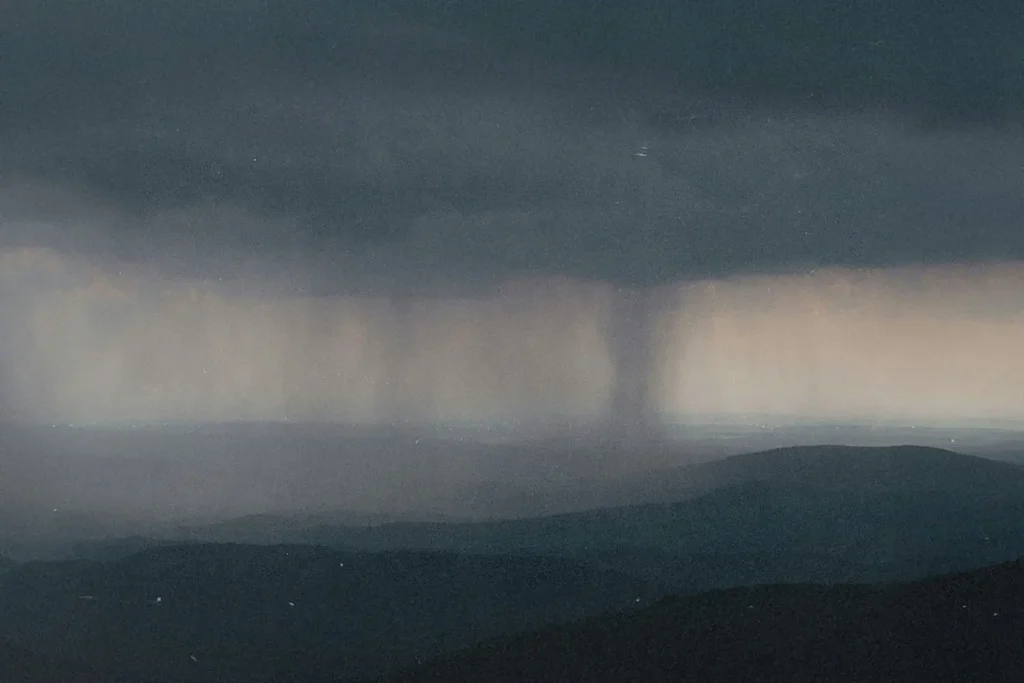 Twister forming in the background of dark gray skies
