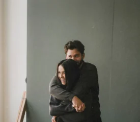 Man hugging a woman from behind as she smiles