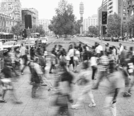 lots of people walking across a crosswalk with a blur for the look of speed