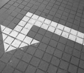 Painted arrow on sidewalk pointing left