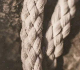 Two pieces of braided fabric resting on a wooden background