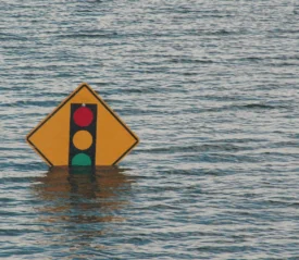 Flood waters that almost cover a traffic light sign
