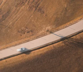 aerial view of car driving on a curving road