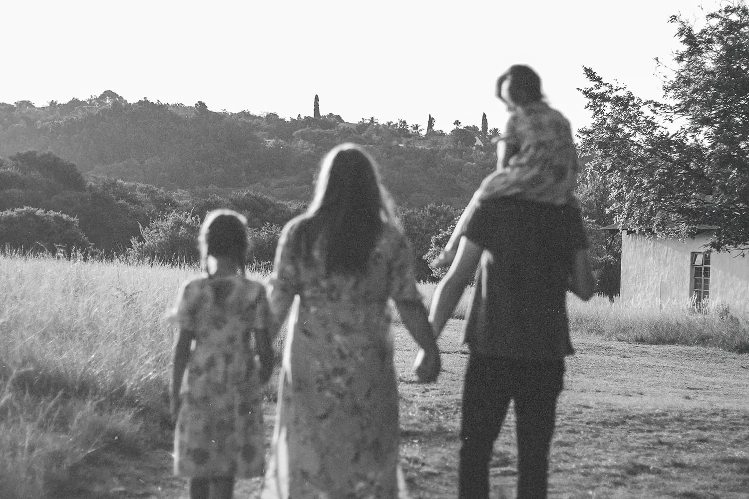 black and white photo of a family walking in a field