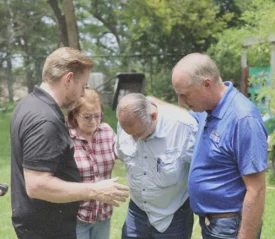 Tim Fox and Riley Stephenson laying hands and praying for couple