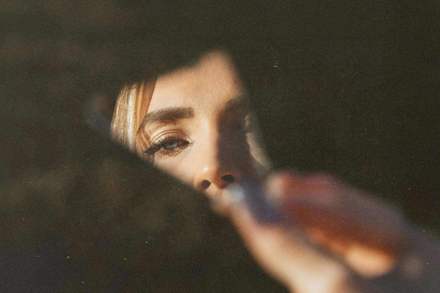 Half of girl's reflection on a chipped piece of mirror