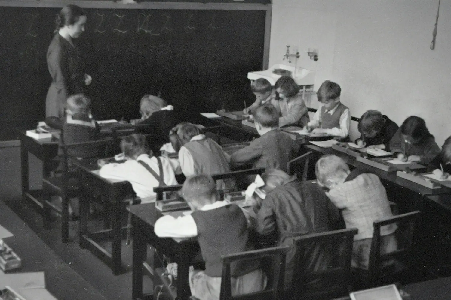 Classroom full of students at their desks with a teacher in the front