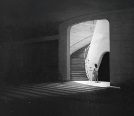 Light shining through an entryway leading to a long staircase