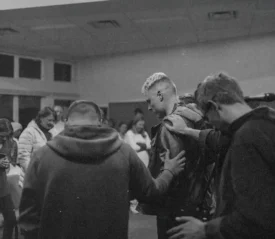Group of people laying hands and praying for a man