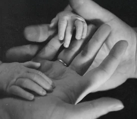 Two baby hands on top of two adult hands