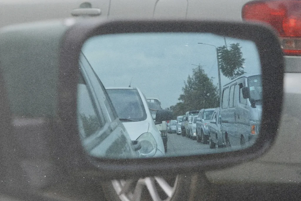 Rearview mirror showing cars in traffic, symbolizing gratitude and perspective in life’s waiting seasons.