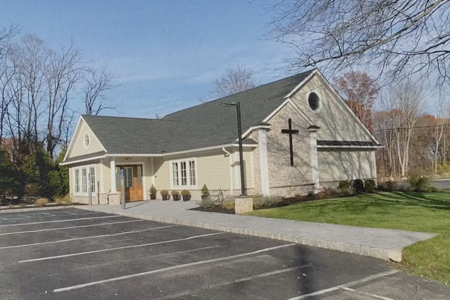 White church building with pitched roof and open parking lot