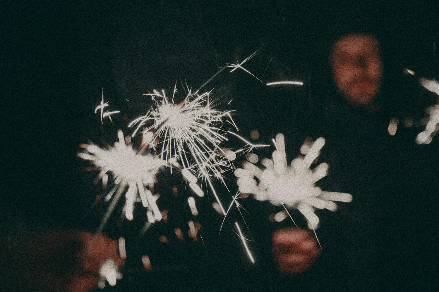 Close-up of sparklers glowing brightly in the dark, symbolizing festive celebration and joy for the New Year