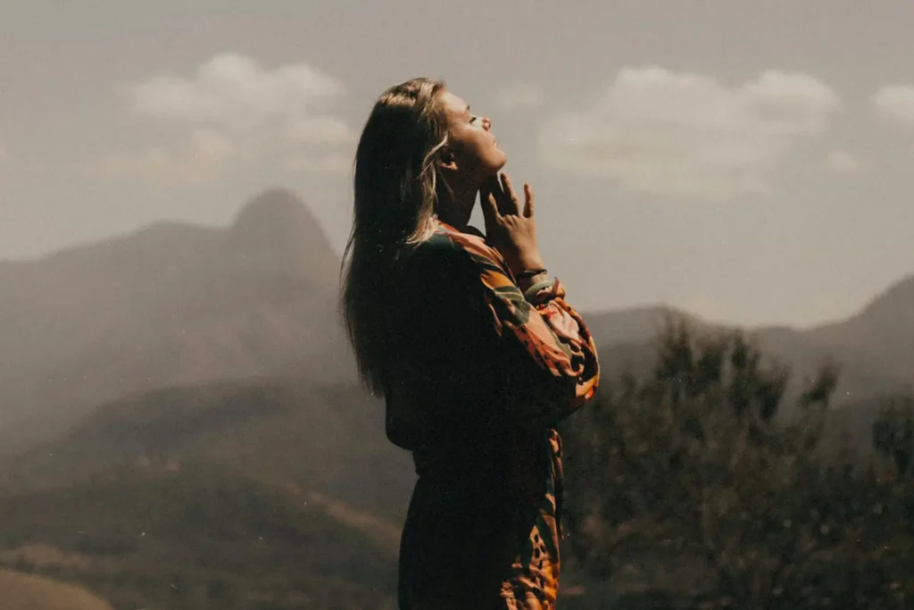 Silhouette of a person standing in a mountain landscape, reflecting on mental health and clearing mental clutter through renewing the mind and guiding thoughts.
