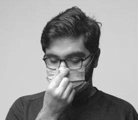 guy in a mask holding his nose