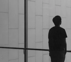 Single man standing at a glass window